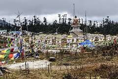 Mandala Top, a sacred Buddhist pilgrimage site featurings 108 stupas, known as Manes, arranged in concentric circles around a golden Buddha statue.