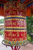 The large prayer wheel with the manrtra “Om Mani Padme Hum” in Tibetan script; at the Gompa Buddhist Temple of Itanagar.