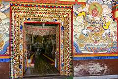 The gate leading into the main assembly hall of Tawang Monastery, with a wall painting of the Heavenly King of the West, a Buddhist god or deva, watching over one cardinal direction of the world.