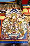 A wall painting of the Heavenly King of the East, a Buddhist god or deva, watching over one cardinal direction of the world, next to the gate leading into the main assembly hall of Tawang Monastery.