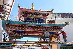 Painters on scaffolding working on the paintings on an ornamental gate in Tawang Monastery.