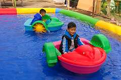 Children in paddle boats on Tawang's Parade Ground.