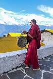 A monk beating a cymbal, as a signal for activities in the monastery.