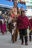 A man with a Monpa headdress leading a man on pony in the Carnival Parade on the first day of the Tawang Festival.
