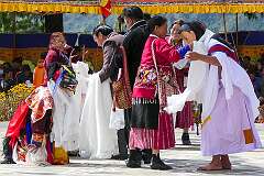 Presenting “khata” ceremonial scarves, to the dancers at the Torgya.
