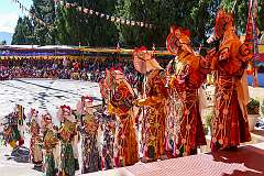 Dancers with elaborate headdresses on the steps from the terrace to the dancing gtound.