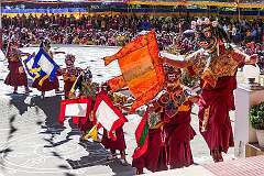 Masked dancers descending the terrace of the monastery to the dancing ground.