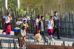 Women arriving with baskets of rice, for the Eli marriage ceremony in Tajang Village; the bride, Nada Yami, walks in front, followed by friends and relatives.