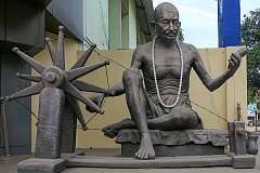 Statue of Mahatma Gandhi with his spinning wheel along Maniram Dewan.