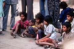 Children watching a man performing with a monkey.