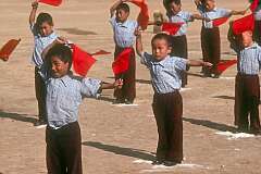 Little boys dancing with red flags during the celebrations.