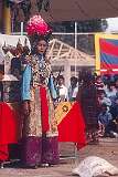 A woman in classic Tibetan dress and headgear, in the Lhamo (Tibetan Opera) performance.