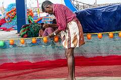 Repairing his fishing net, at the Chellanam Harbour.