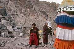 Two young monks blowing a conch shell to announce the start of the daily “puja”, a religious ceremony performed by the monastic community.