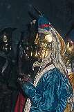 A monk with gilded headgear and mask dances in a ceremony inside the monastery.