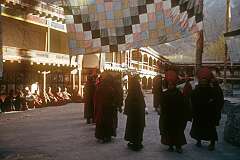 Senior monks in their robes and hats in the inner courtyard of Hemis Gompa.