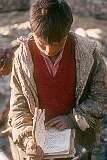 A boy reading Urdu from a book in Leh.
