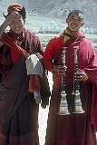 Two Buddhist monks, carrying “Radong” trumpets.