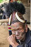Penlung, an elderly Konyak Naga man with traditional headdress, ornamented with bear fur and boar tusks. His facial tattoos indicate he was a headhunter in his younger years.