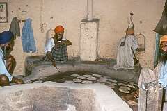 Men baking chapattis; the Golden Temple is an open house of worship for all people, from all walks of life and faiths, and food is served to all visitors who want it.