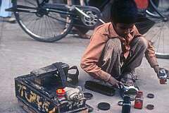 A young shoeshine boy polishing sandals in Chandigarh.