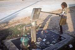 A girl fetching water from a communal water pump, Kanchipuram.
