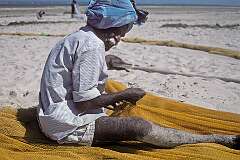 Repairing his fishing net on the beach in Dhanushkodi.