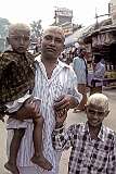 A father and his two children in Palani, their heads shaved as a dedication to the god Shiva and covered with tumeric after their visit to the Dhandayuthapani Swamy Temple.