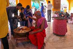 A priest with devotees in the Tripura Sundari Mandir, a Hindu temple of the Goddess Tripura Sundari, better known locally as Devi Tripureshwari, in Udaipur.