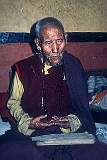 An elderly lama with Buddhist scriptures in Jangsa Gompa, a Bhutanese Monastery, founded in 1678.