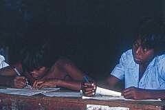 Two boys writing lessons.