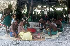Young men having their meal outside the maneaba of Roreti village.