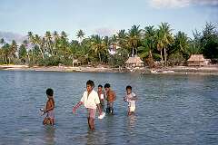 Children crossing at low tide between the islets of Buota and Tanaea.