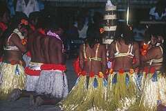 Dancers in traditional dress praying at the wedding cake, during the wedding reception.