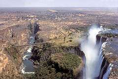 The mighty Victoria Falls or Mosi oa Tunya ("The smoke that thunders"), with the Victoria Falls Bridge between Zimbabwe and Zambia; it was built in 1905.
